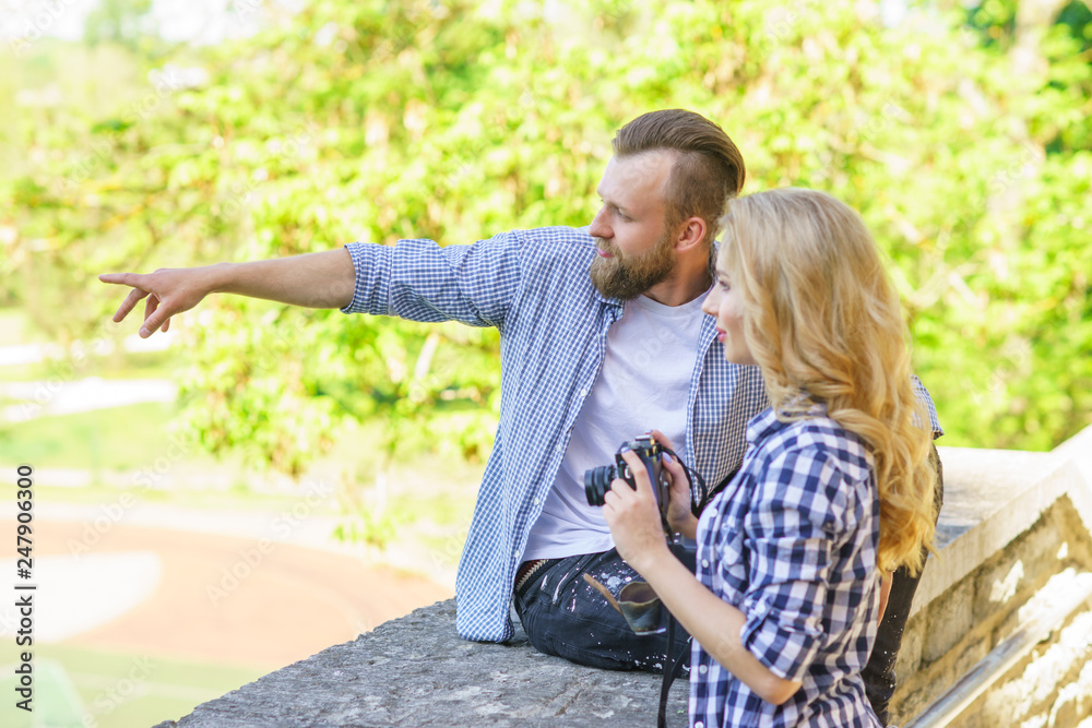 Fototapeta premium Man and woman having date outdoor. Girl wit a photo camera and her boyfriend.
