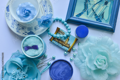 female accessories blue and a cup and saucer spread out on the table