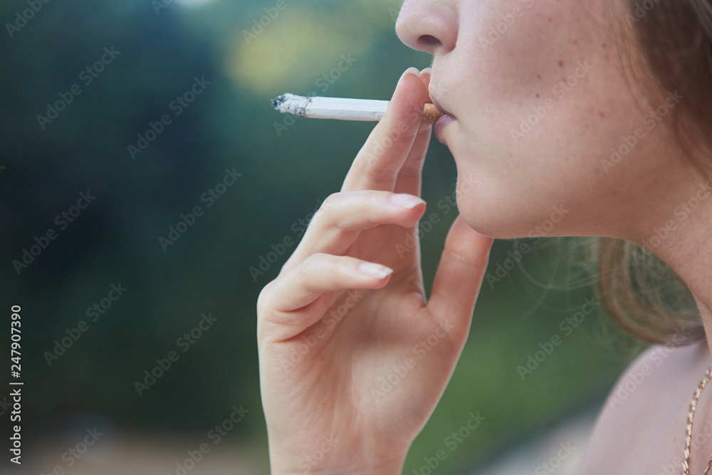 Obraz premium Young girl Smoking a cigarette. Close up. Lifestyle