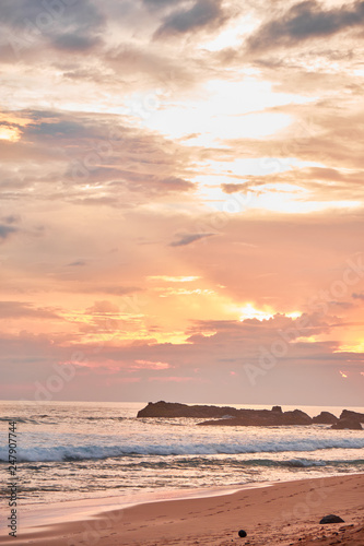 Stunning sunset on the beach overlooking the ocean and the waves. 