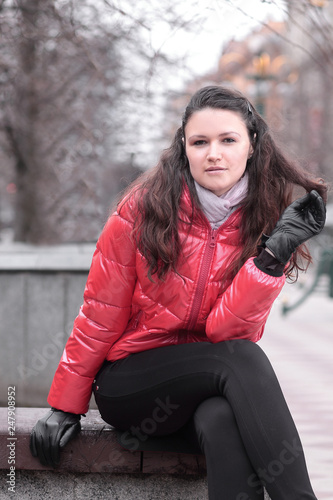 portrait of young woman sitting on bench in autumn day © yurolaitsalbert