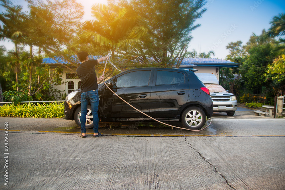 Fototapeta premium Man cleaning car,Car parked on street