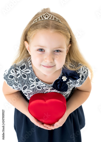 A little girl is holding a heart.