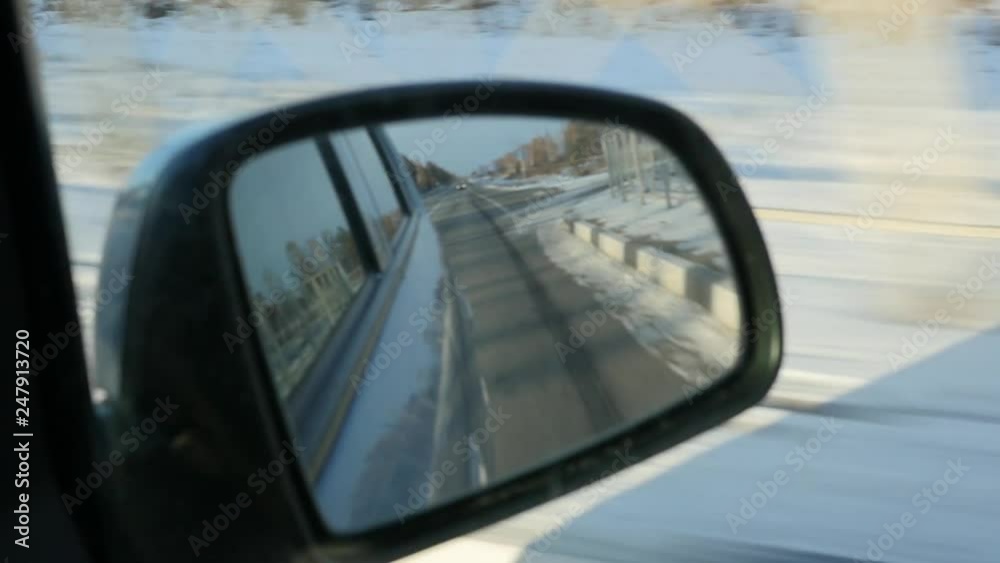 reflection of the winter road in the rearview mirror. winter season. slow motion reflection of the winter road in the rearview mirror. winter season. slow motion