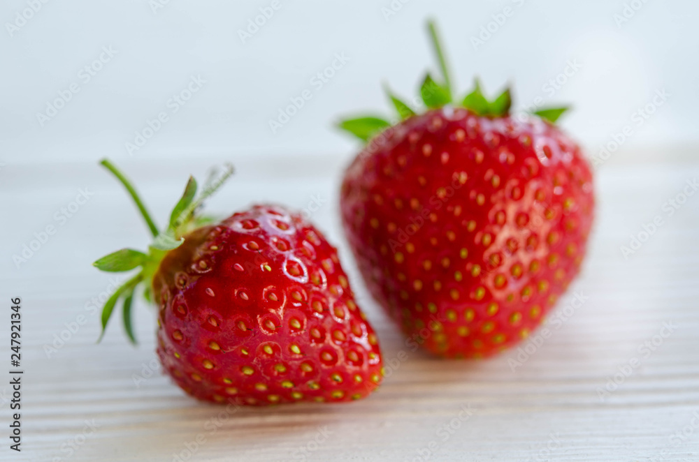 two strawberries on a wooden table
