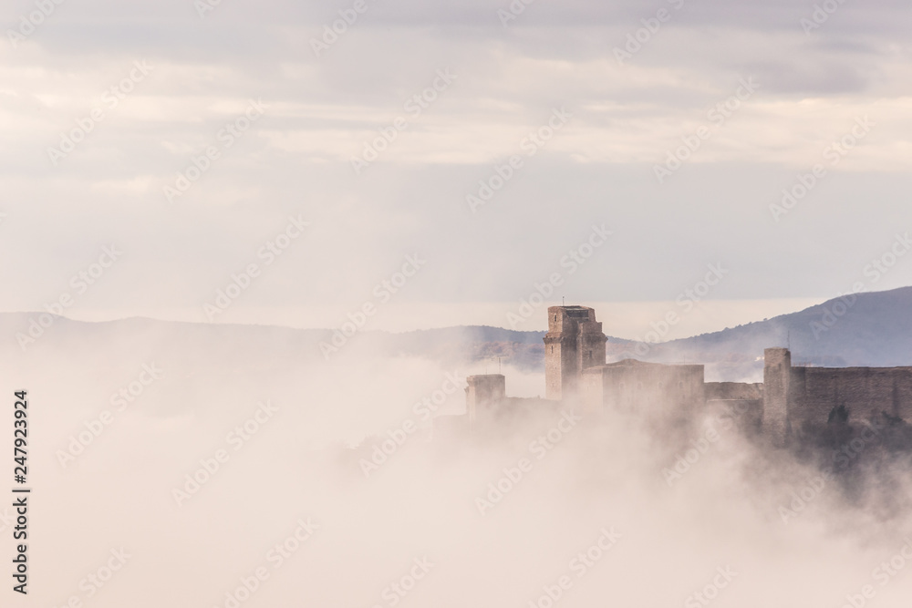 A view of Rocca Maggiore castle in Assisi (Umbria, Italy) in the middle of fog