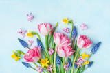 Bouquet of beautiful spring flowers on pastel blue table top view. Greeting card for International Women Day. Flat lay.