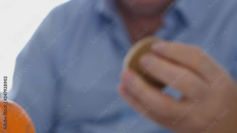 Man Breakfast Take with Hand and Study Careful a Kiwi Fruit from the Table Man Breakfast Take with Hand and Study Careful a Kiwi Fruit from the Table