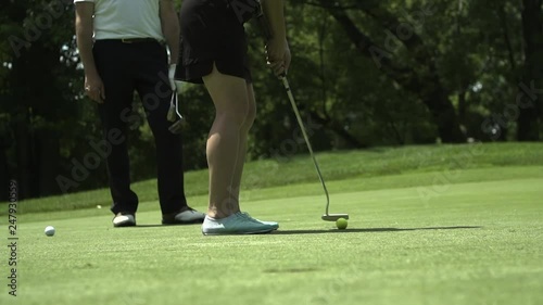 A woman celebrates after making a long putt. photo