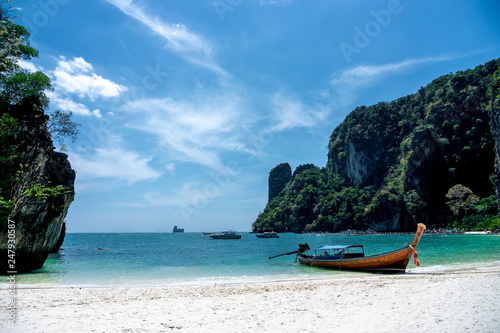 A long tail boat on the tropical white sand beach at Krabi, Thialand.