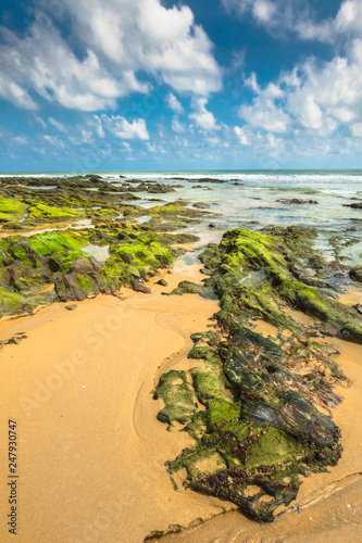 Beautiful view of Batu Pelanduk, Terengganu. Blue sky scene with waves motion between rocks at the beach. photo