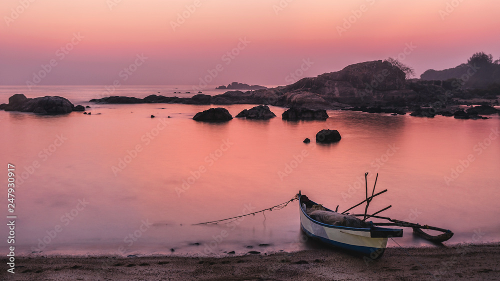 beach tropical paradise at pink sunset with a boat