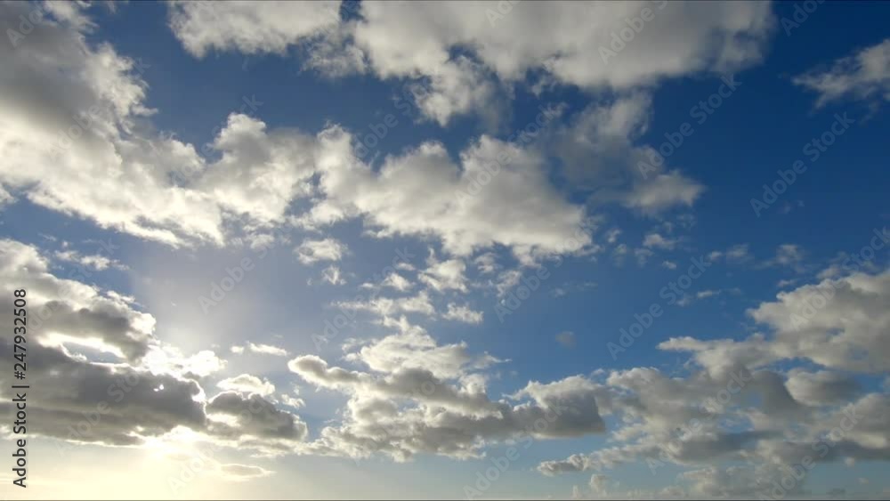 Time lapse clip of white fluffy clouds over blue sky