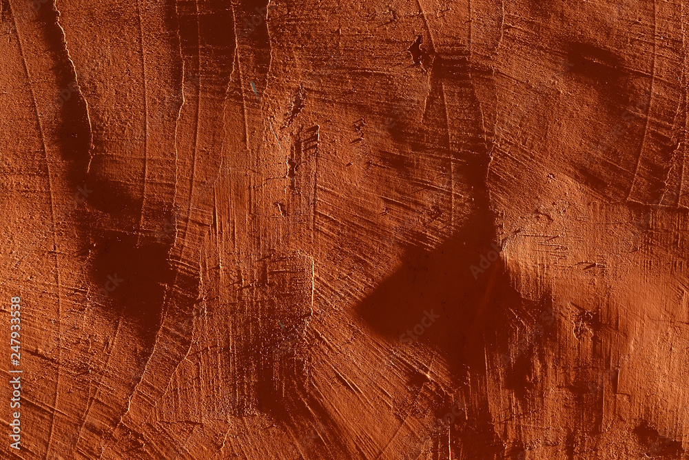 Naklejka premium close-up: plastered, rough orange wall, illuminated by bright side lights. With scratches, deep shadows and contrast 3