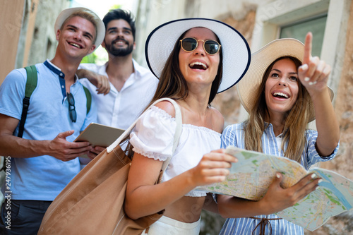 Happy group of friends tourists sightseeing in city on vacation