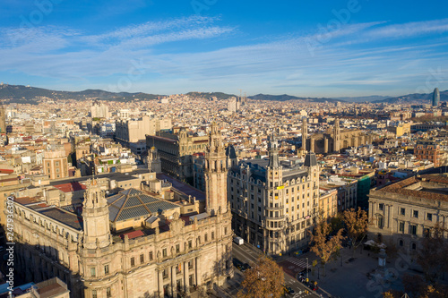 Aerial; drone view of old spanish buildings in Barcelona illuminated by warm morning light; old roofs of low houses in Barcelonetta area; Sunny day in touristic capital of province of Catalonia, Spain