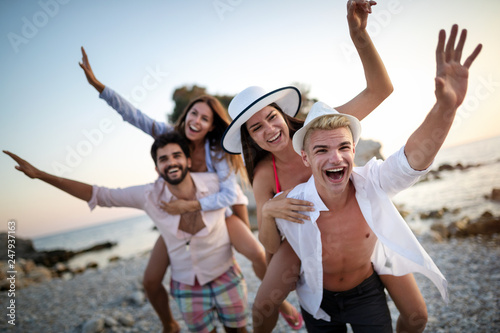 Group of friends having fun on the beach on vacation