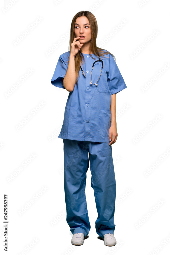 Full body Young nurse having doubts while looking up on isolated background Full body Young nurse having doubts while looking up on isolated background