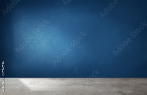 Dark blue wall in an empty room with a concrete floor photo