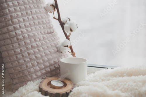 Warm and cozy window seat with cushions and blanket and cup, still life from home interior, the concept of home comfort 