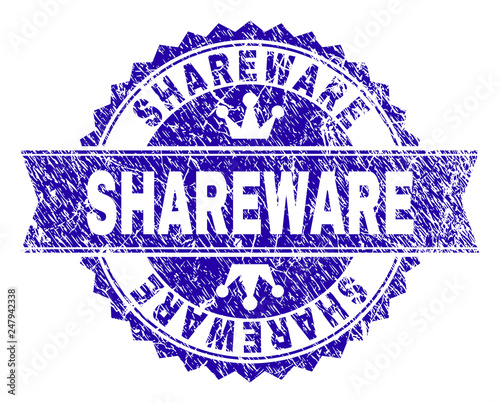 SHAREWARE rosette seal watermark with distress texture. Designed with round rosette, ribbon and small crowns. Blue vector rubber watermark of SHAREWARE caption with corroded texture.