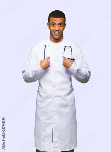 Young afro american man doctor with surprise facial expression on isolated background