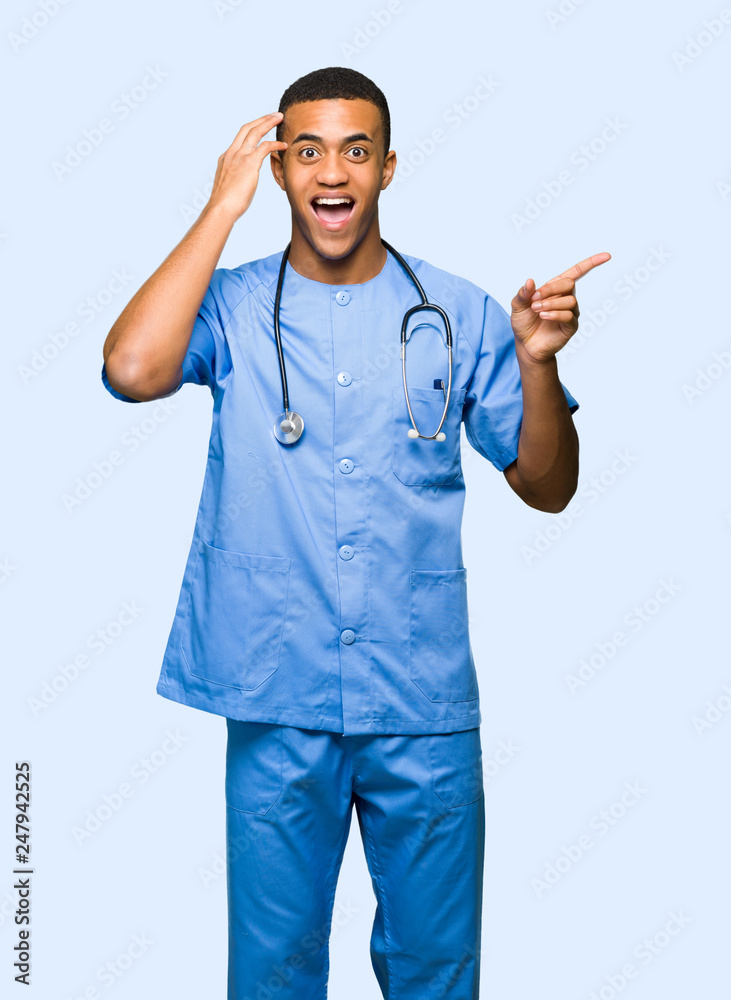 Surgeon doctor man pointing finger to the side and presenting a product on isolated background Surgeon doctor man pointing finger to the side and presenting a product on isolated background