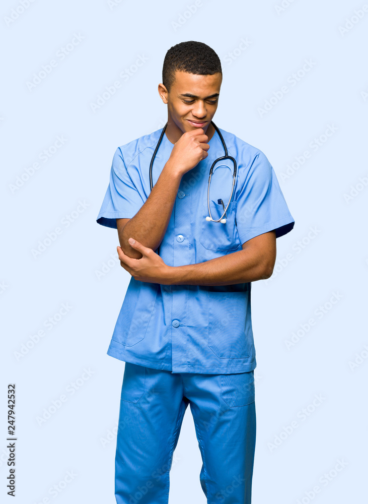 Surgeon doctor man looking down with the hand on the chin on isolated background Surgeon doctor man looking down with the hand on the chin on isolated background