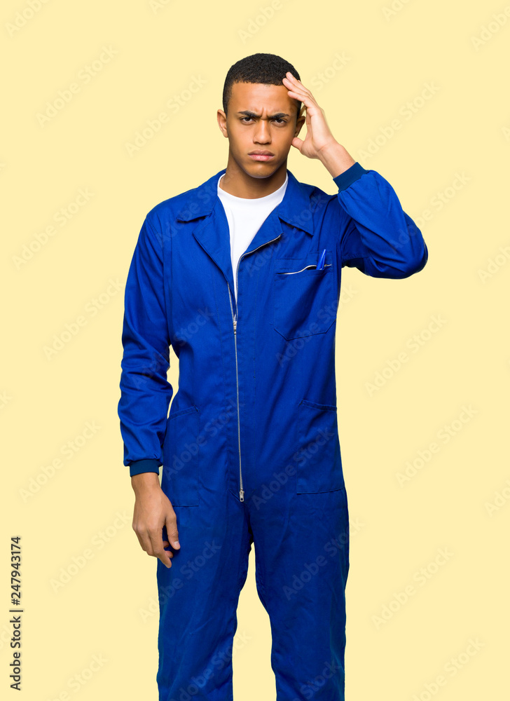 Young afro american worker man with an expression of frustration and not understanding on isolated background Young afro american worker man with an expression of frustration and not understanding on isolated background
