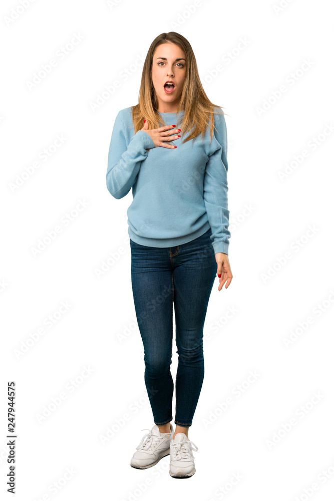 Full body of Blonde woman with blue shirt surprised and shocked while  looking right on white background Stock Photo