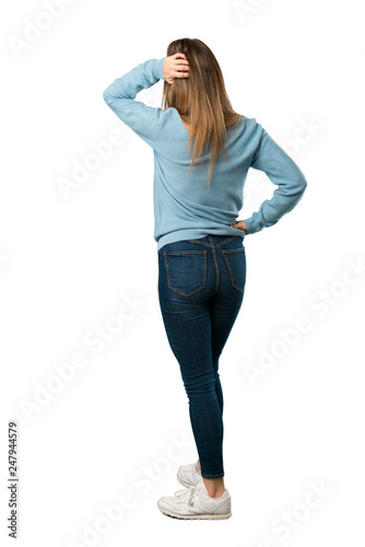 Full body of Blonde woman with blue shirt on back position looking back while scratching head on white background