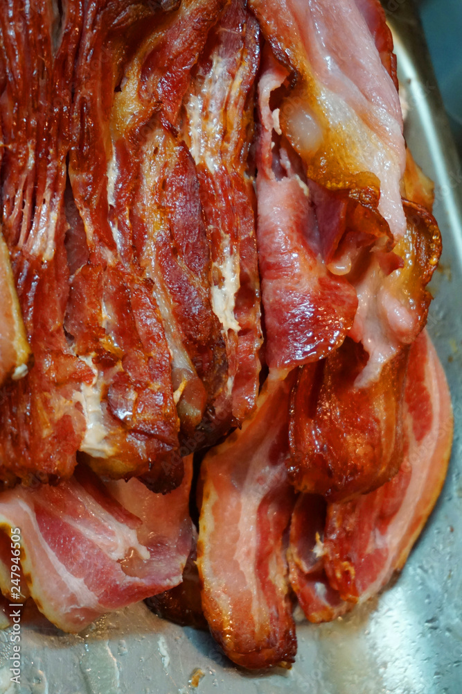 Delicious baked crispy bacon slices with pork belly fat and skin crispy beautiful color close up unhealthy food Delicious baked crispy bacon slices with pork belly fat and skin crispy beautiful color close up unhealthy food