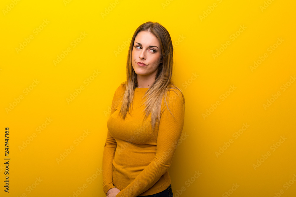 Young woman on yellow background feeling upset Young woman on yellow background feeling upset