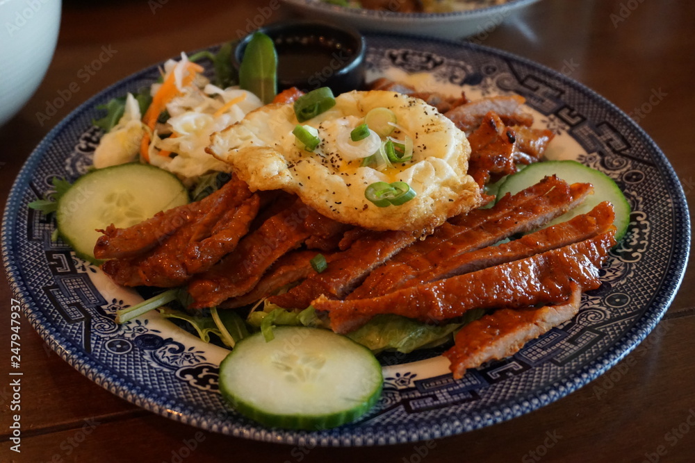 Com tam - Vietnamese broken rice with pickles steak grilled pork ribs cucumber onion oil sweet chilies garlic fish sauce fried egg omelet Asian cuisine Com tam - Vietnamese broken rice with pickles steak grilled pork ribs cucumber onion oil sweet chilies garlic fish sauce fried egg omelet Asian cuisine