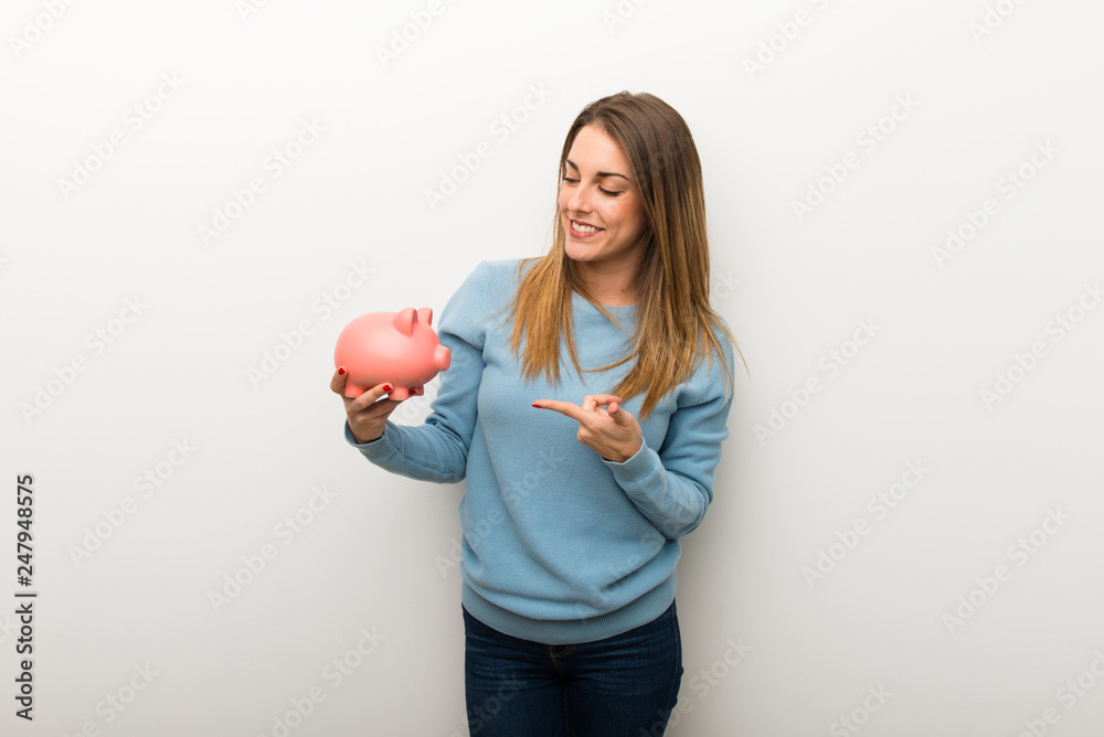 Blonde woman on isolated white background holding a piggybank Blonde woman on isolated white background holding a piggybank