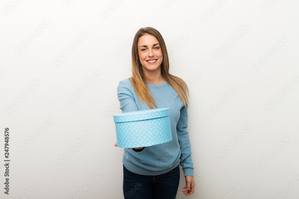 Blonde woman on isolated white background holding a gift in hands Blonde woman on isolated white background holding a gift in hands