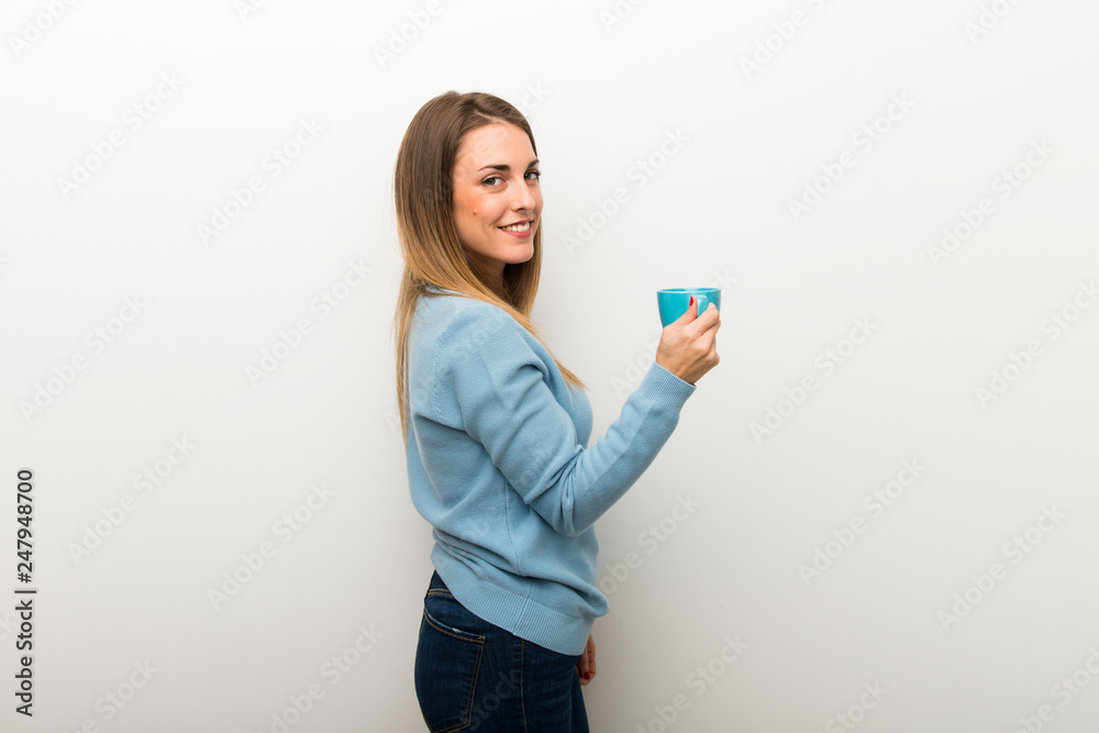 Blonde woman on isolated white background holding a hot cup of coffee Blonde woman on isolated white background holding a hot cup of coffee