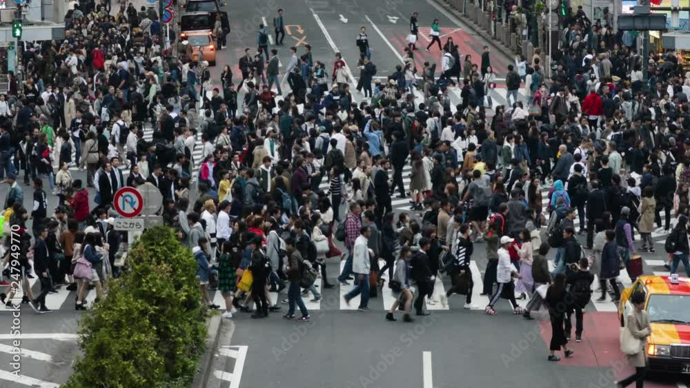 Thousands of people walk across the famous Shibuya Crossing in Tokyo Japan