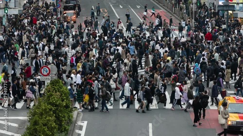 Thousands of people walk across the famous Shibuya Crossing in Tokyo Japan