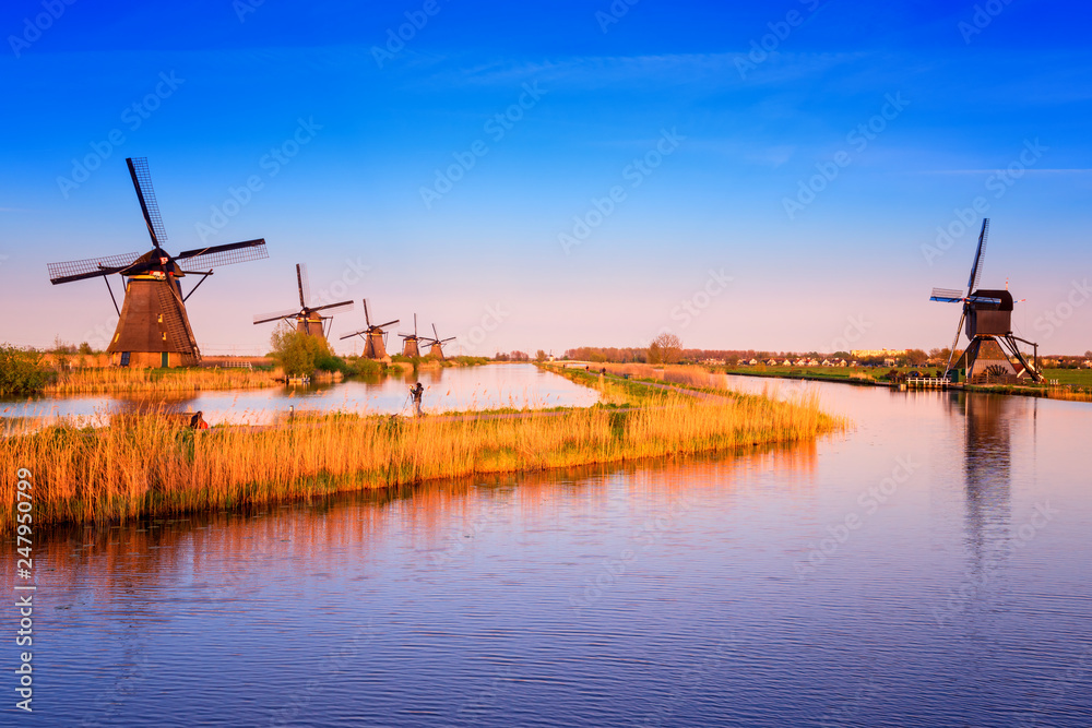 Amazing nature, scenic sunset landscape, windmills, blue sky and water. Traditional dutch countryside, famous village of mills Kinderdijk, popular tourist attraction in Netherlands (Holland)