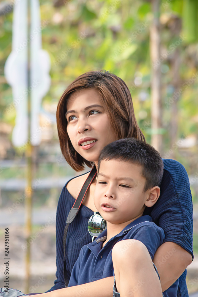 Portrait Son and Mother Sitting in a vegetable garden Background green plants. Portrait Son and Mother Sitting in a vegetable garden Background green plants.