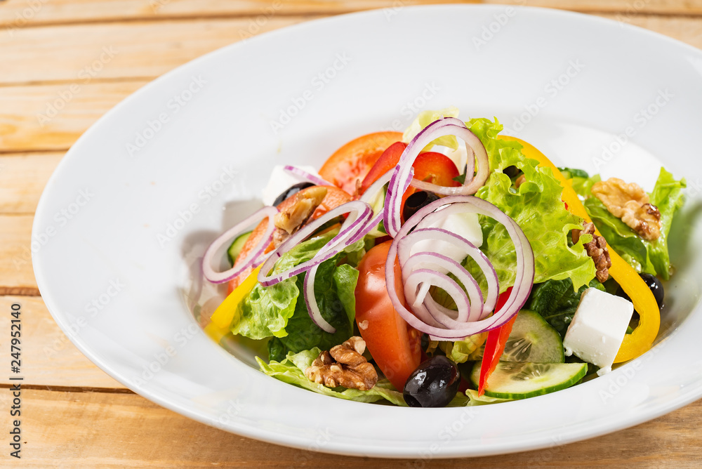 Greek salad with feta cheese on the wooden background Greek salad with feta cheese on the wooden background