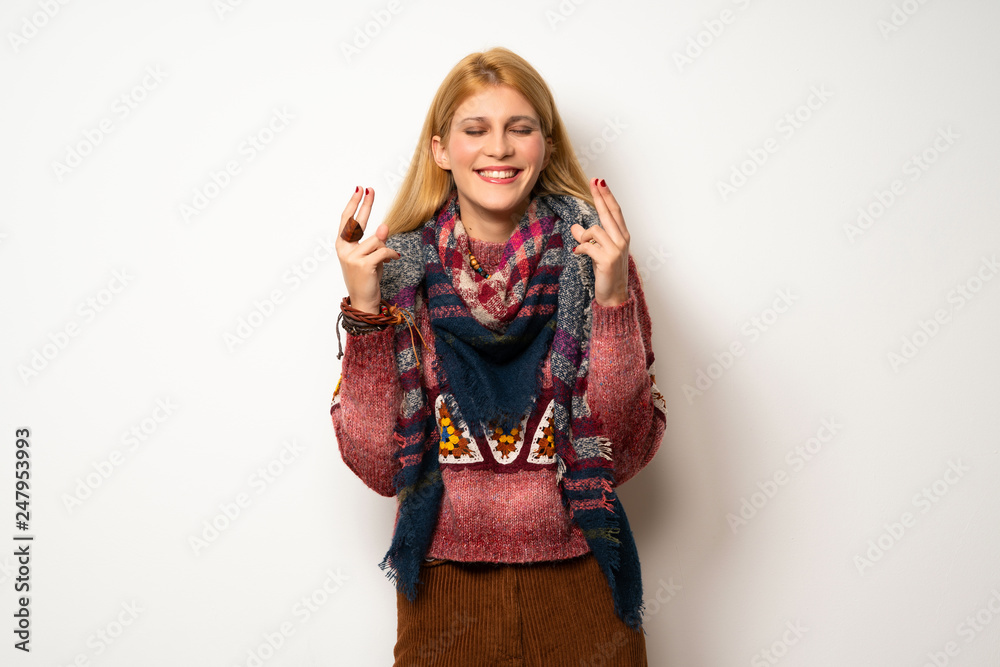 Hippie woman over white wall with fingers crossing and wishing the best Hippie woman over white wall with fingers crossing and wishing the best