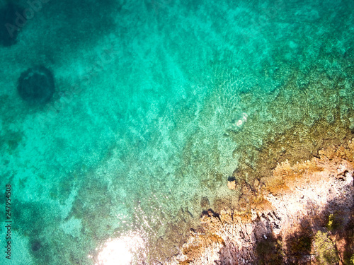 top view of rocky shore crystal clear Adriatic Sea, drone shot