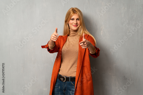 Woman over textured background points finger at you while smiling