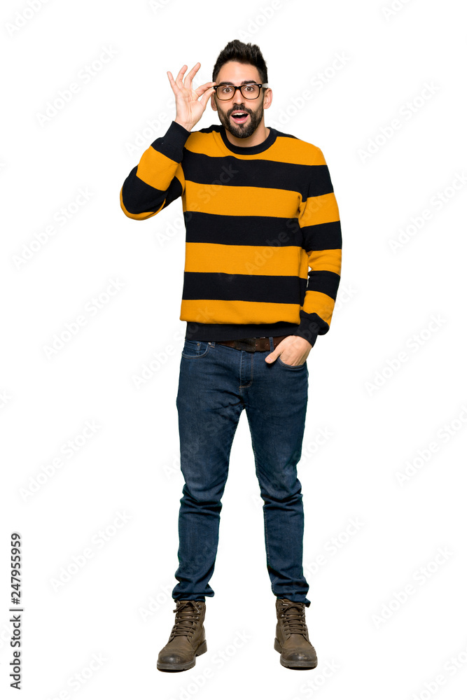 Full-length shot of Handsome man with striped sweater with glasses and surprised on isolated white background Full-length shot of Handsome man with striped sweater with glasses and surprised on isolated white background