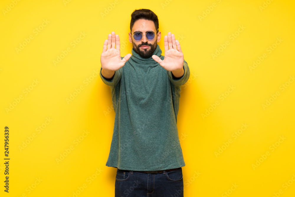 Handsome man with sunglasses making stop gesture for disappointed with an opinion