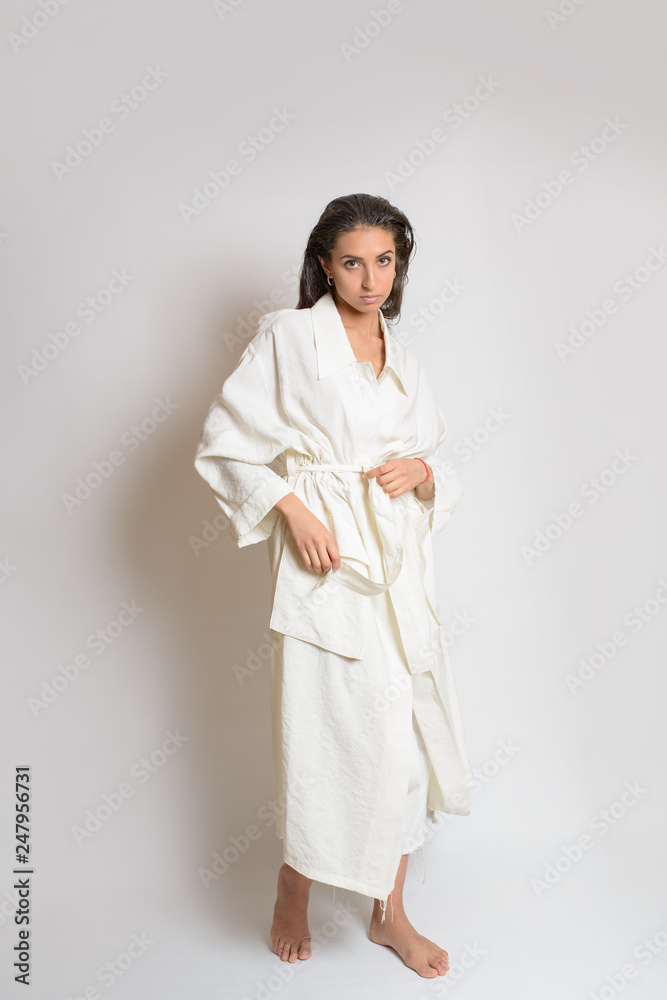 Beautiful woman in white dress or bathrobe with wet style hair on white background Beautiful woman in white dress or bathrobe with wet style hair on white background