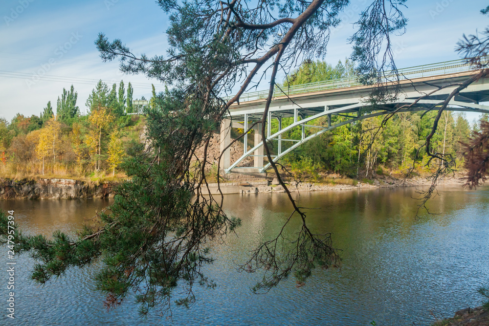 Autumn landscape of bridge and Kymijoki river waters in Finland, Kymenlaakso, Kouvola, Myllykoski.