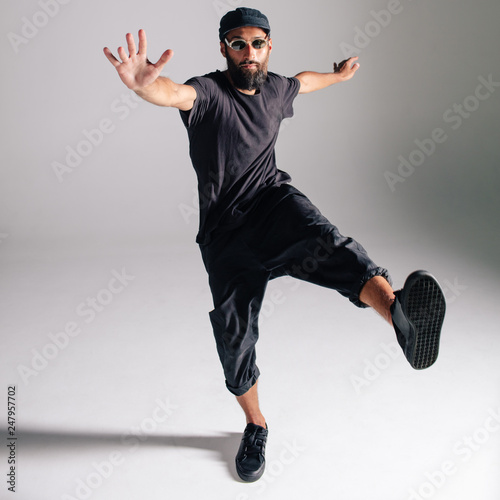 Tablou pe pânză Hip hop dancer moving and jumping in photostudio